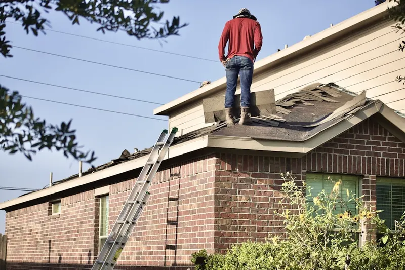 Professional roofer working on a residential roof in Ludingtonville